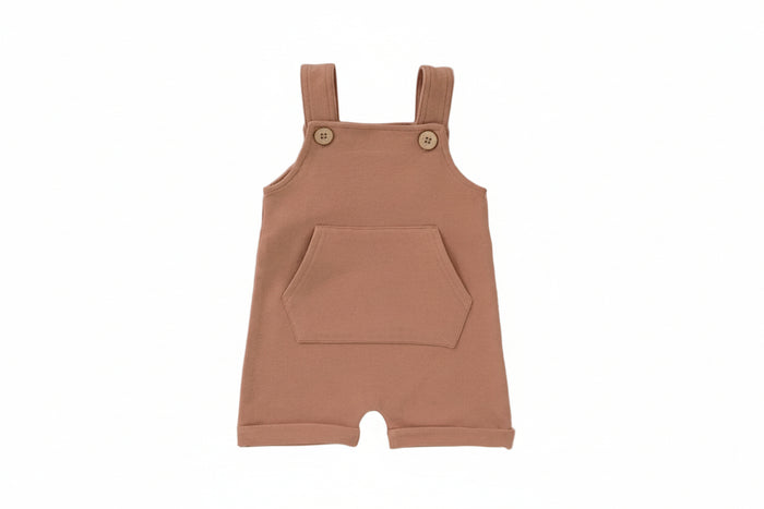 Brown baby romper with buttons on a light gray background with decorative elements.