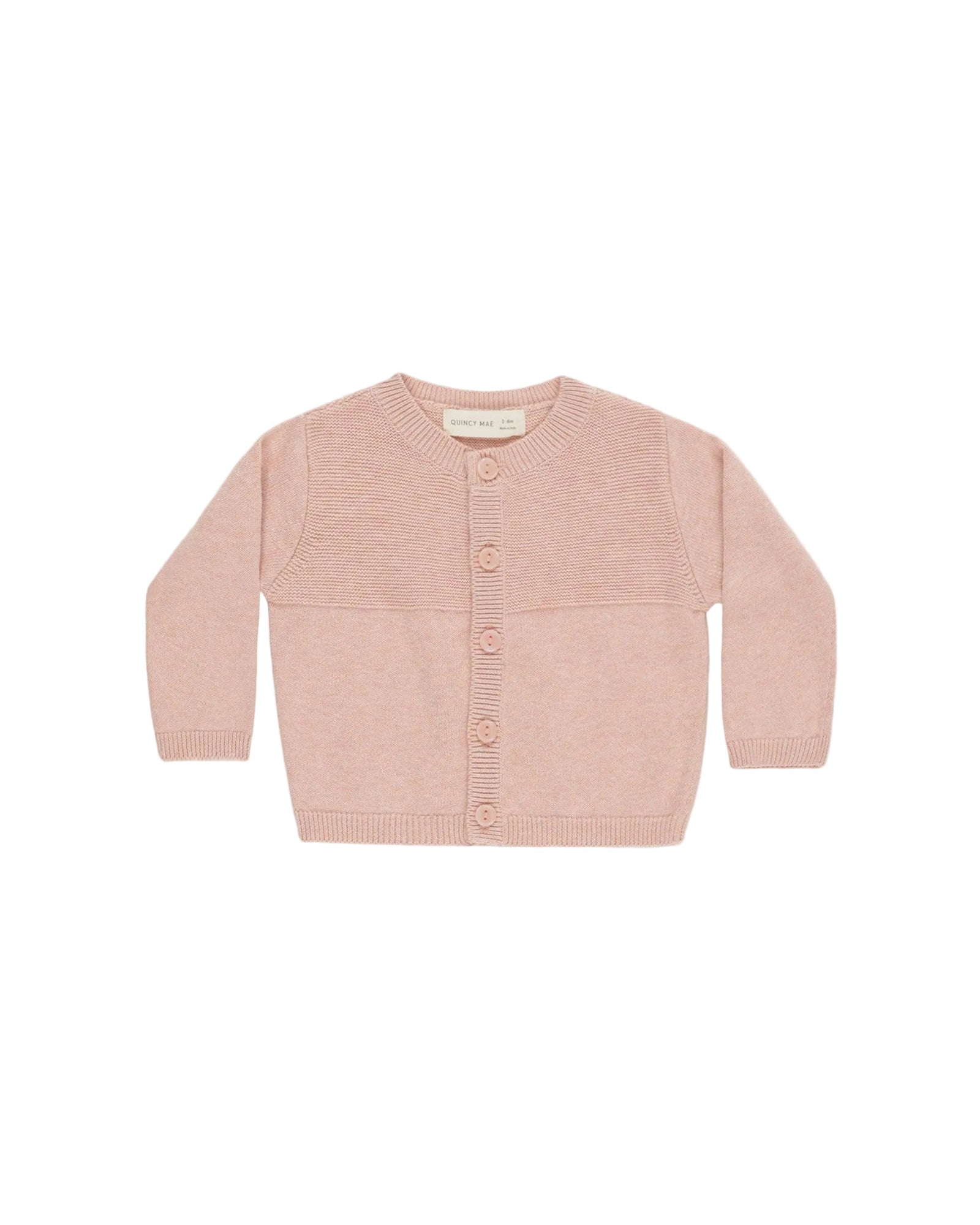 Pink baby cardigan on a light beige background