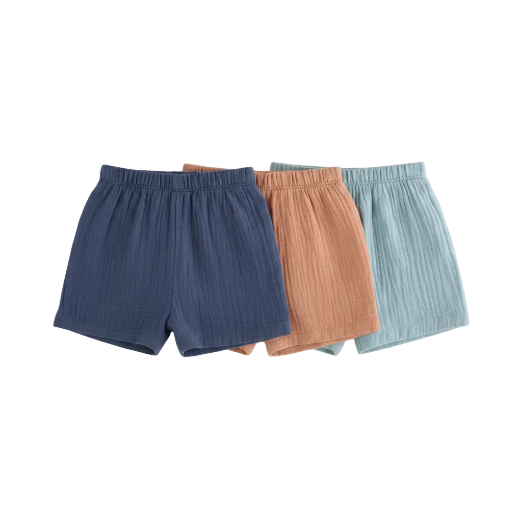 Three pairs of shorts in blue, brown, and light blue hanging on a rack against a white background.
