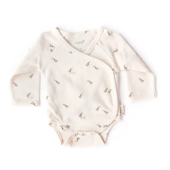 Baby onesie with long sleeves and a pattern on a white background