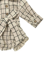 Beige and black checkered baby romper with ruffled details on a white background