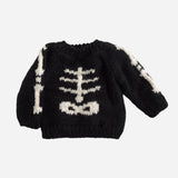 Black sweater with white skeleton design on a light gray background