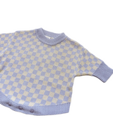 A baby knit sweater with a lavender and cream checkerboard pattern, featuring a ribbed crew neck, short sleeves, and a matching ribbed hem.