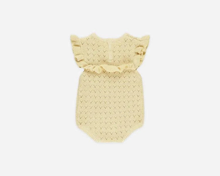 A pale yellow crocheted baby romper with ruffled shoulder straps, displayed flat against a light gray background.
