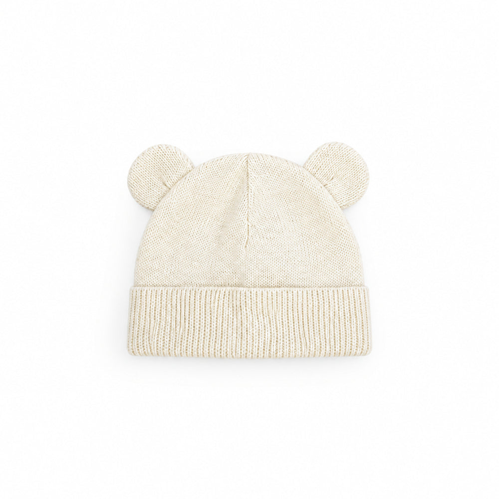 Baby blanket with bear pattern, cream hat with bear ears, and wooden ring toy on a white background