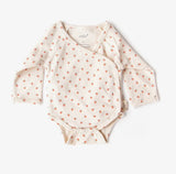 Baby onesie with long sleeves and a pattern on a white background