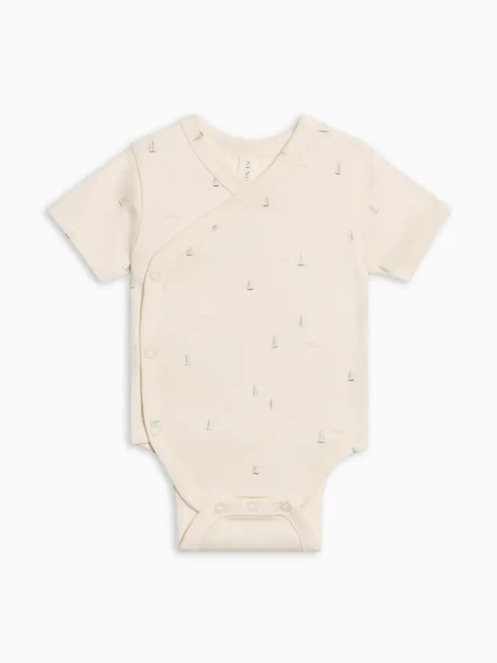 Beige baby onesie with small patterns on a white background