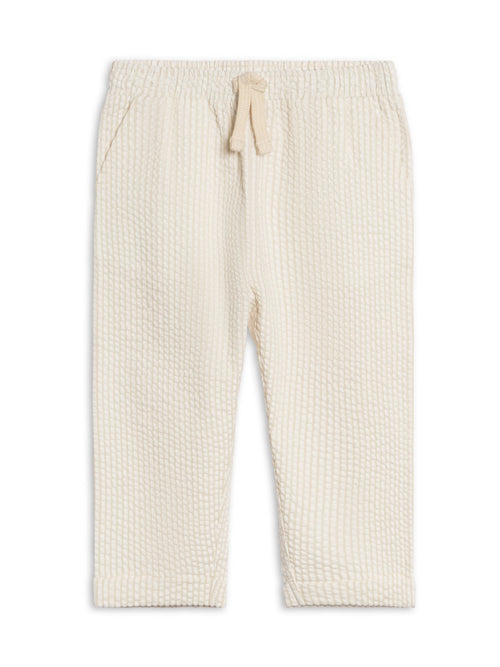 Cream-colored ribbed pants on a white background