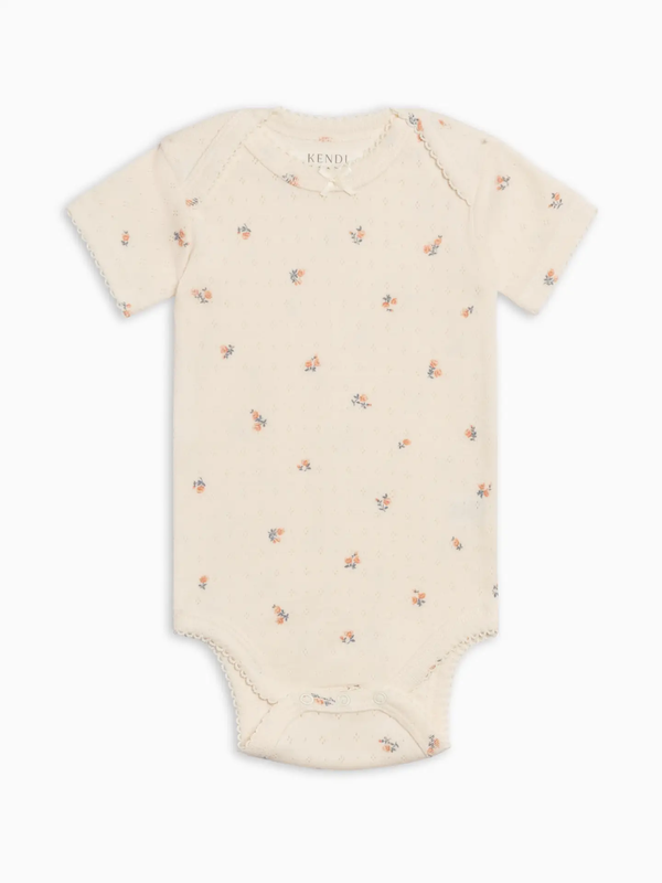 Beige baby onesie with small floral pattern on a white background