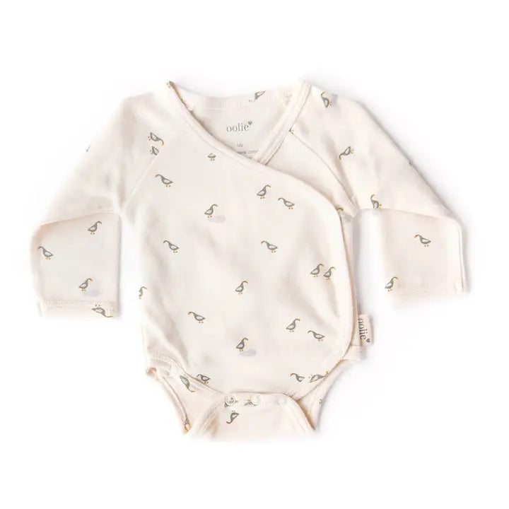 Baby onesie with long sleeves and a pattern on a white background